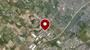 Aerial view of a landscape with a red map pin indicating a location.