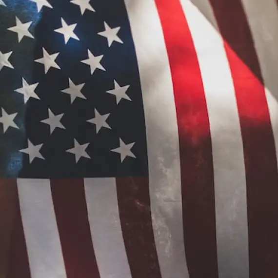 Close-up of the American flag waving in the wind. Red and white stripes with white stars on a blue field.